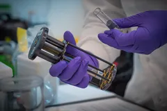Laboratorní vědec drží zkumavku a zařízení pro vědecký výzkum